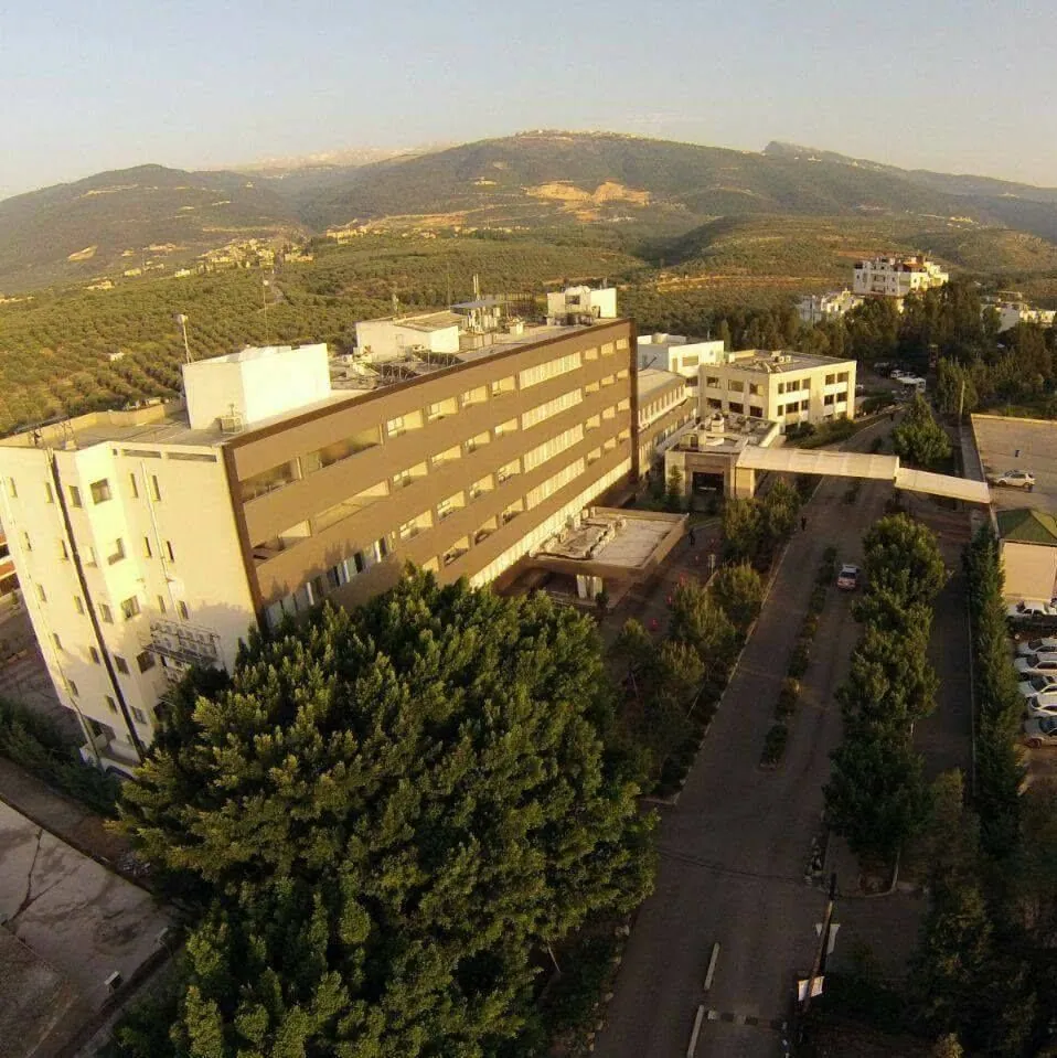 Aerial view of CHN Hospital among the olive terraces of Zgharta